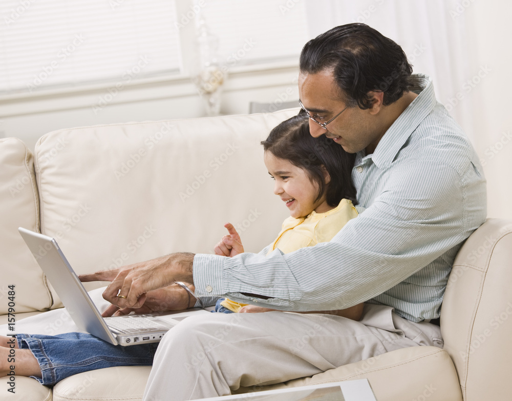 Indian Father and Daughter Look at Laptop Together Indian Father and Daughter Look at Laptop Together