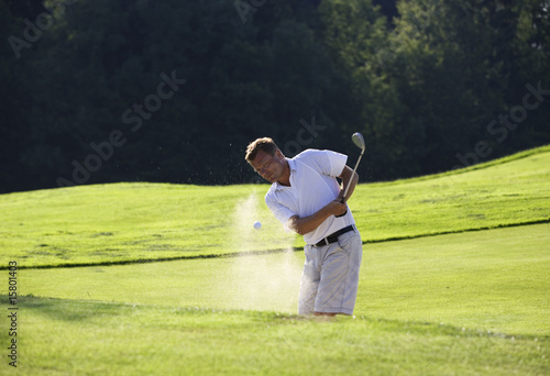 Golfspieler beim abschlag im Sandbunker,