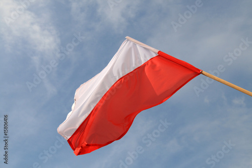 Polish flag waving in the wind on the cloudy sky