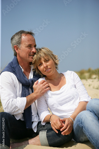 Portrait d'un homme et d'une femme assis sur le sable © auremar