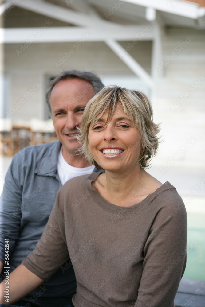femme souriante près d'un homme devant une maison femme souriante près d'un homme devant une maison