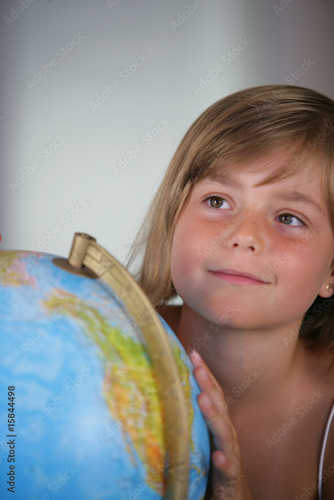 Portrait d'une petite fille souriante près d'un globe Portrait d'une petite fille souriante près d'un globe