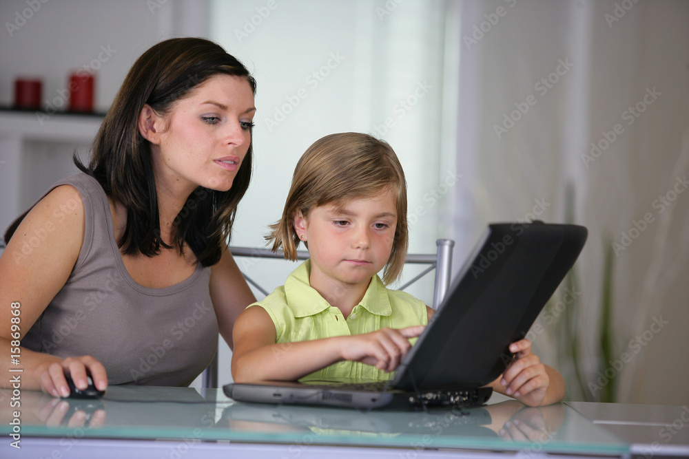 femme et d'une petite fille devant un ordinateur portable femme et d'une petite fille devant un ordinateur portable