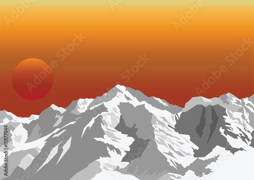 Snow capped mountain range against a dawn or dusk sky