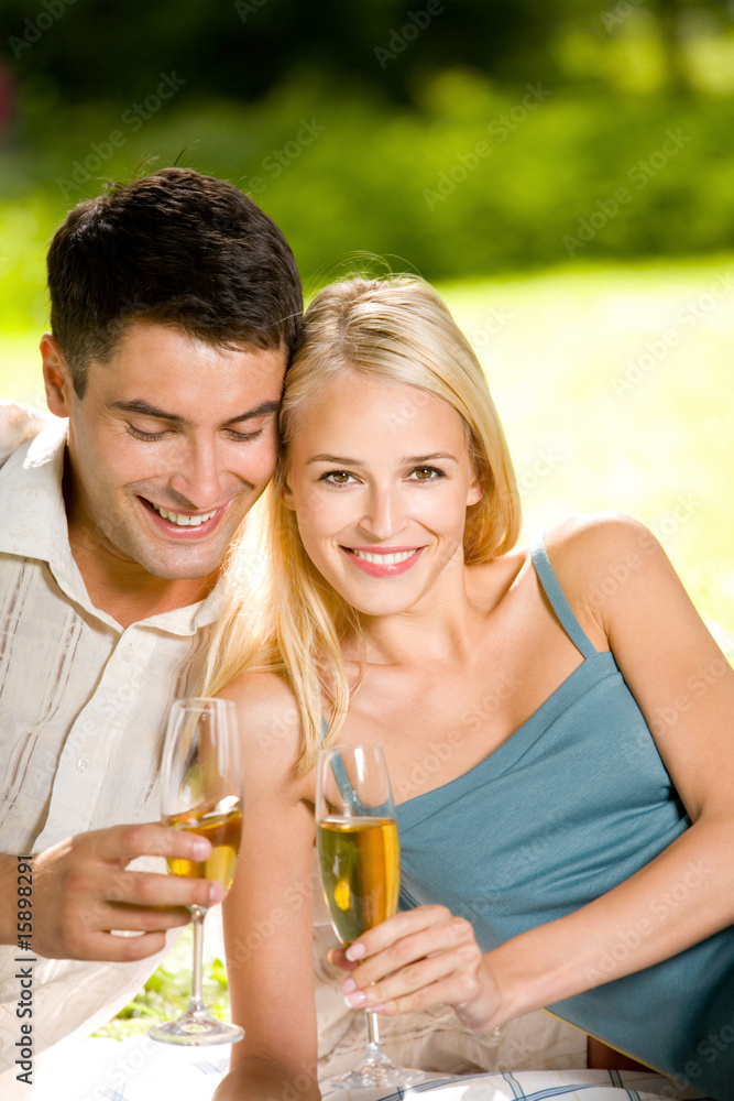 Couple celebrating with champagne together, outdoors Couple celebrating with champagne together, outdoors