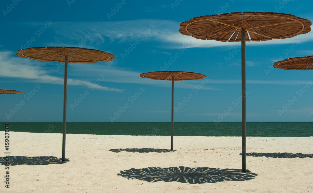 Wooden sun-covers at the sandy beach