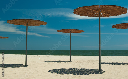 Wooden sun-covers at the sandy beach