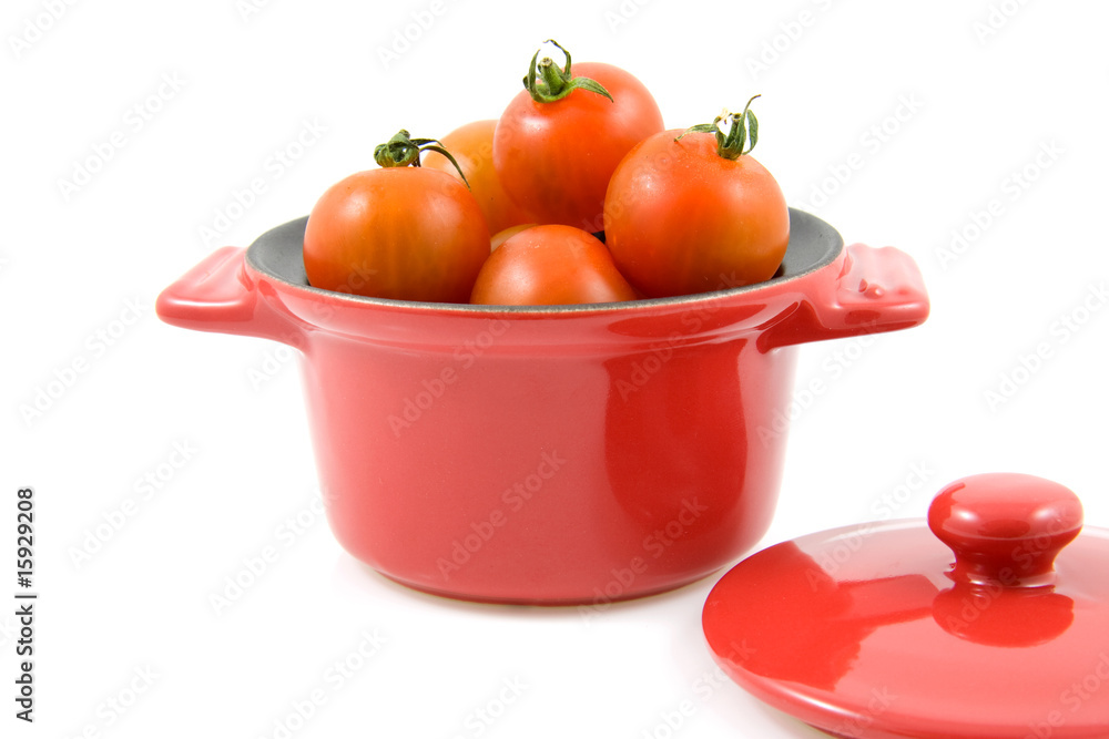 red casserole with cherry tomatoes on white background red casserole with cherry tomatoes on white background