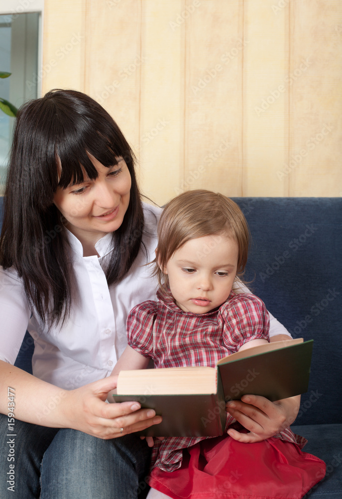 Mother reading a book with her little daughter Mother reading a book with her little daughter