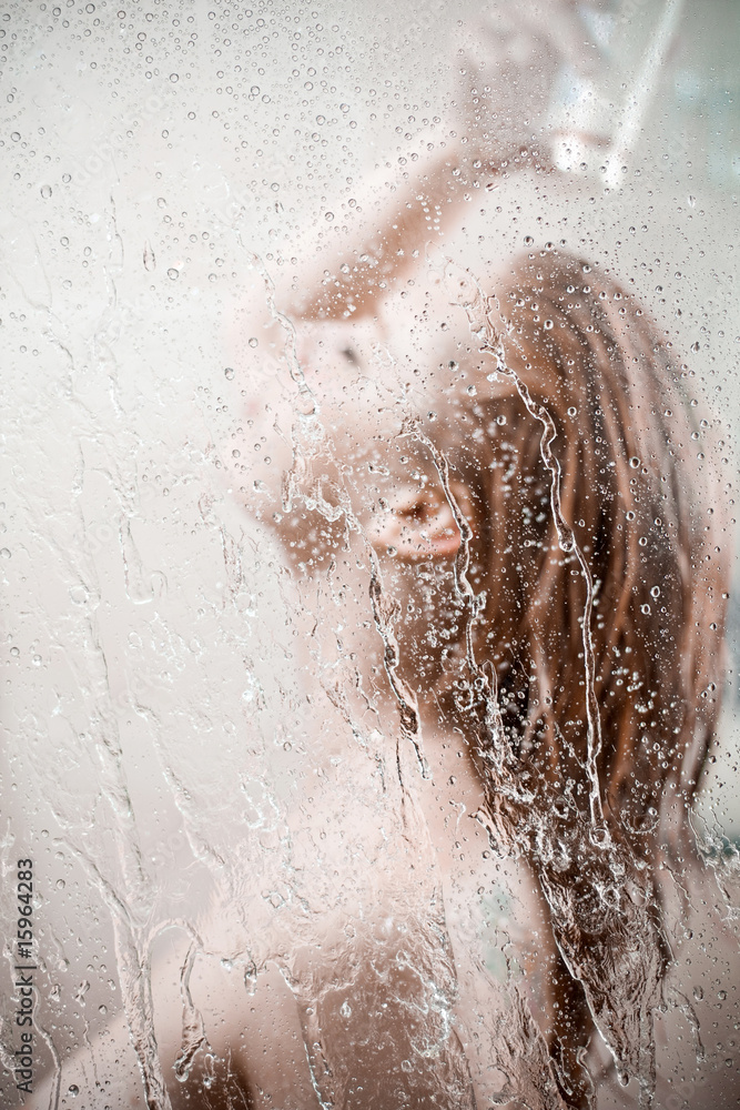 Fototapeta premium showering woman shot from behind glass