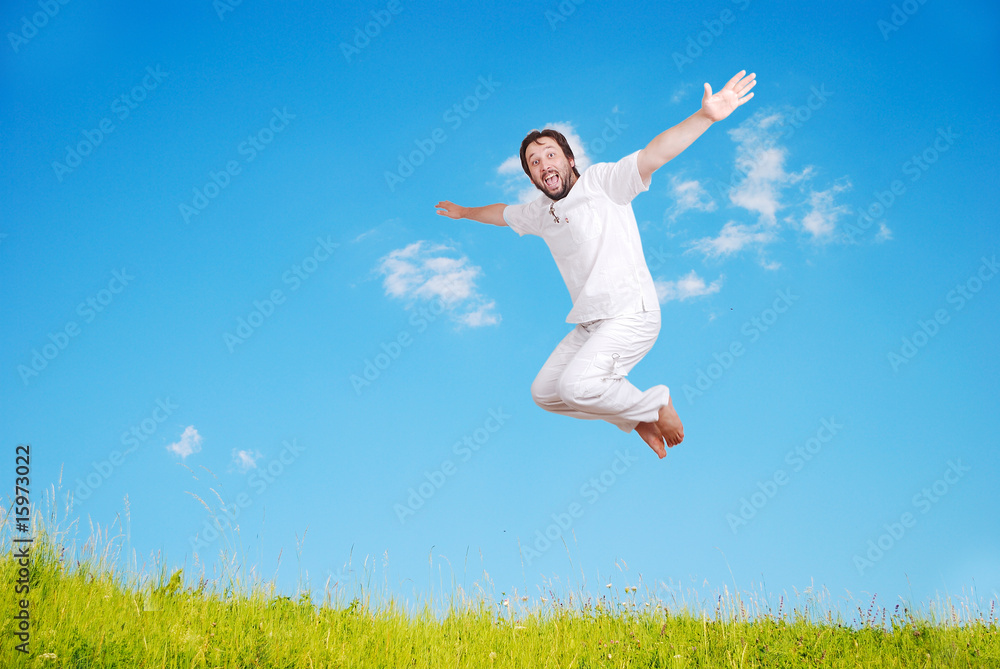 Happy young mane in white jumping on beautiful meadow Happy young mane in white jumping on beautiful meadow