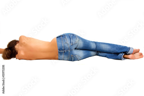 Topless girl in blue jeans laying on the floor