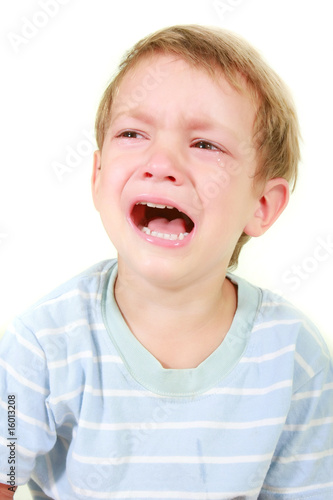 crying toddler boy over white