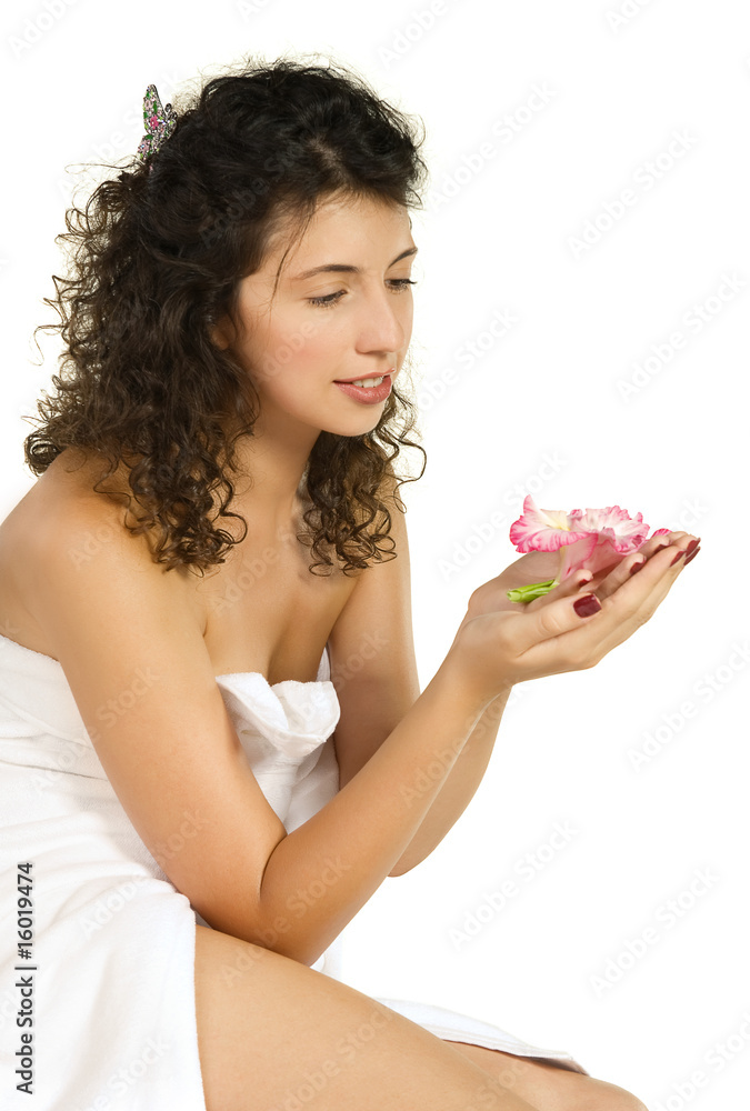 Beautiful woman in white towel holding a flower isolated Beautiful woman in white towel holding a flower isolated