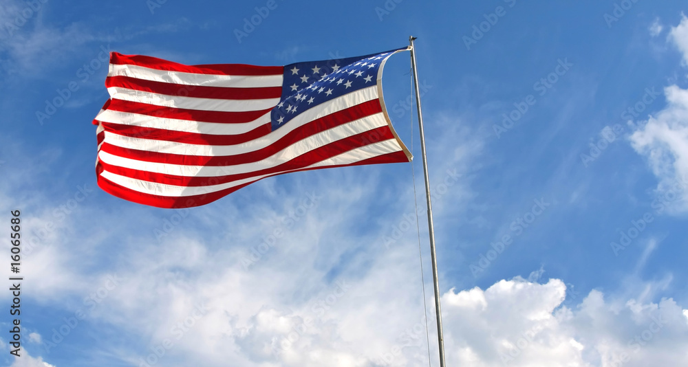 Waving American flag against a blue sky background Waving American flag against a blue sky background