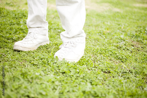 芝生の上に立つ男性の足元