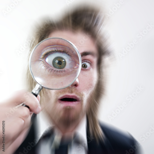 Fotografija homme stupéfait regardant à la loupe