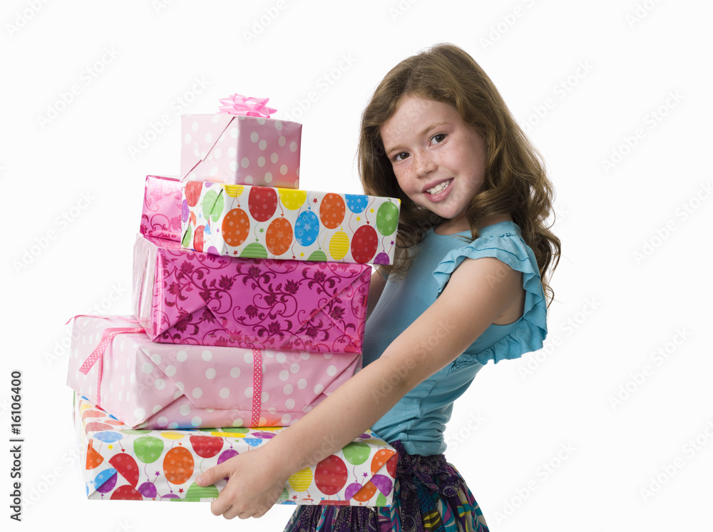 Young girl in party clothes holding large pile of presents Young girl in party clothes holding large pile of presents