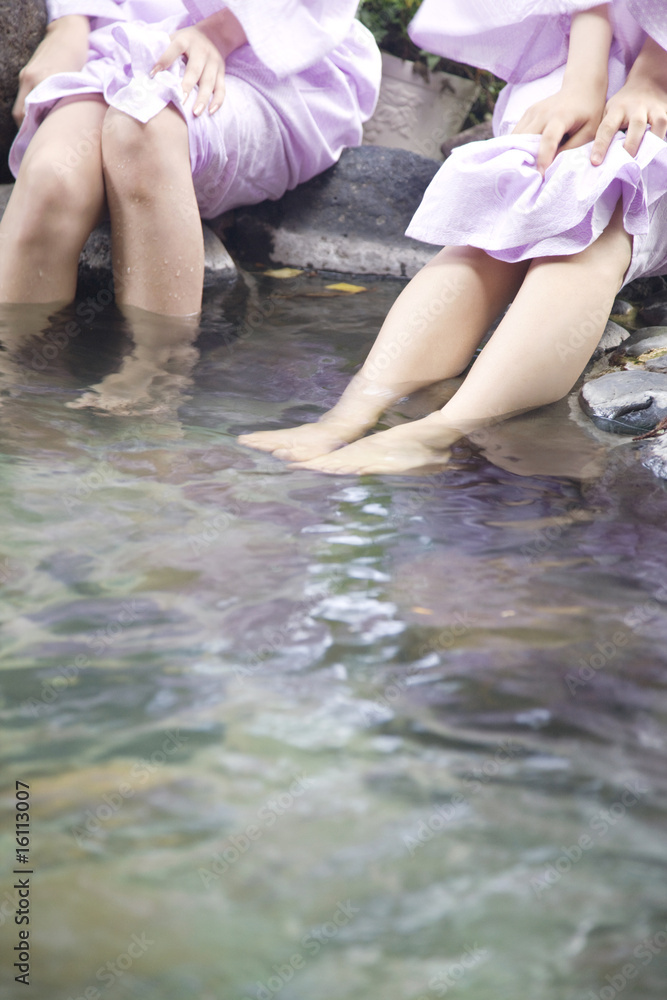 Fototapeta premium 温泉に足をつけている女性