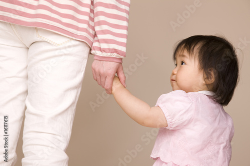 母親と手を繋いで歩いている赤ちゃん