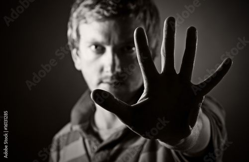 Photos Low Key Shot of a Male Looking at the Camera Through his Hand