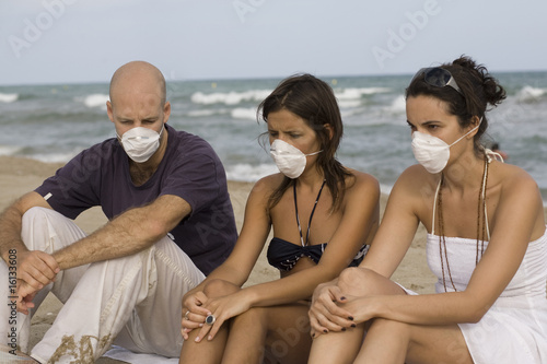 Three young adults with protection masks against birdflu photo