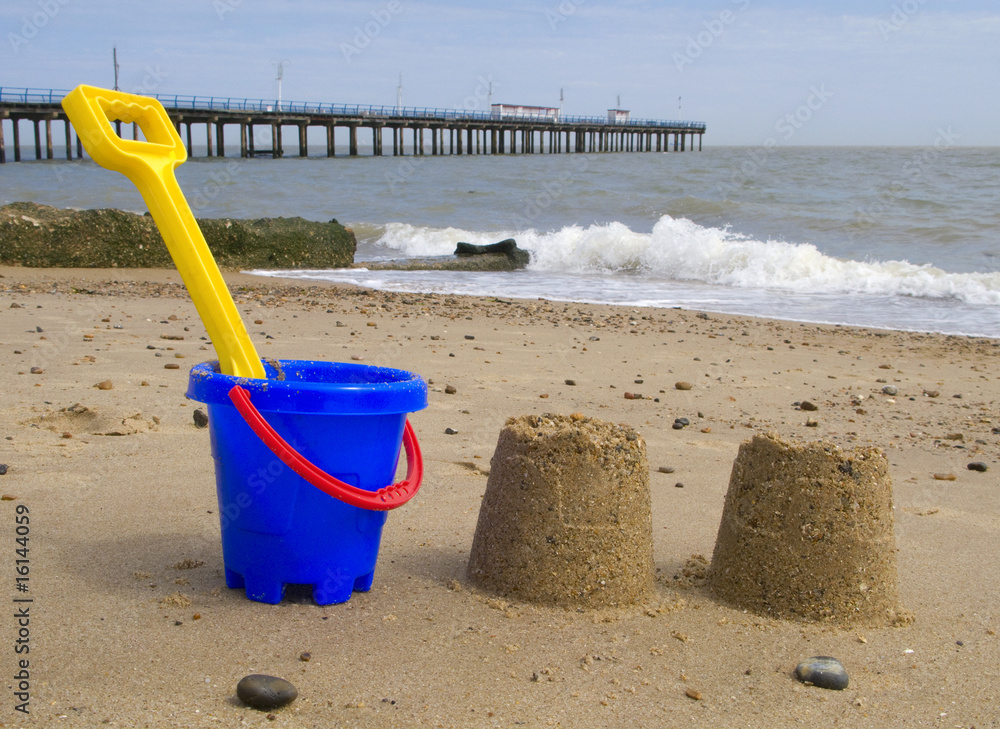 Kids bucket, spade and sandcastles on Felixstowe beach. Kids bucket, spade and sandcastles on Felixstowe beach.