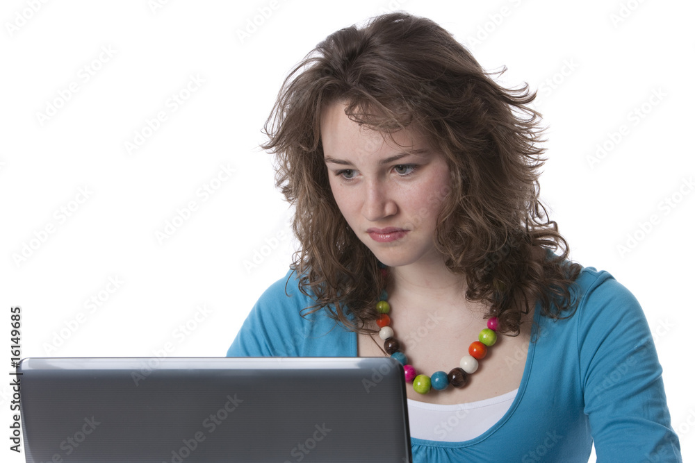 Naklejka premium Teenage girl is sitting behind a laptop