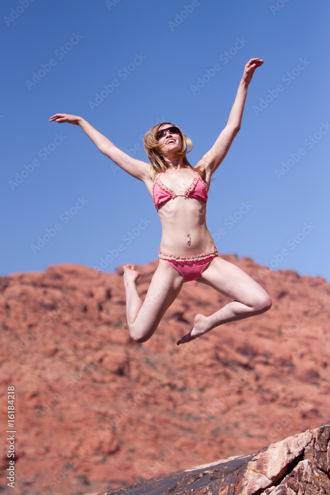 Woman in bikini jumping outdoors Woman in bikini jumping outdoors