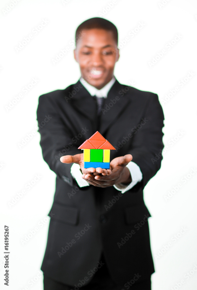 Friendly businessman holding a house in his hands Friendly businessman holding a house in his hands