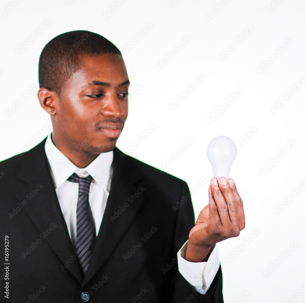 Confident businessman looking at a light bulb Confident businessman looking at a light bulb