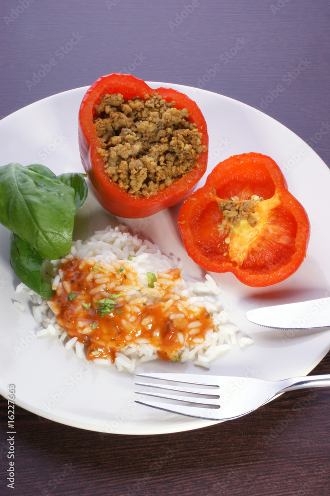 Red mince filled paprika with basil leaf, rice and sauce Red mince filled paprika with basil leaf, rice and sauce