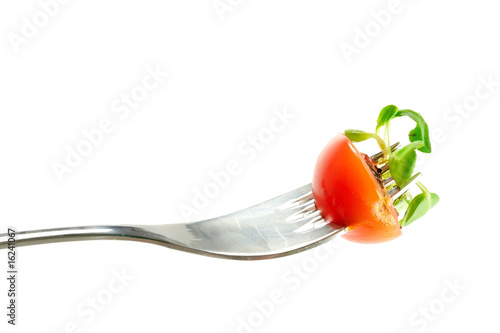 Cherry tomato and basil leaf on fork isolated on white
