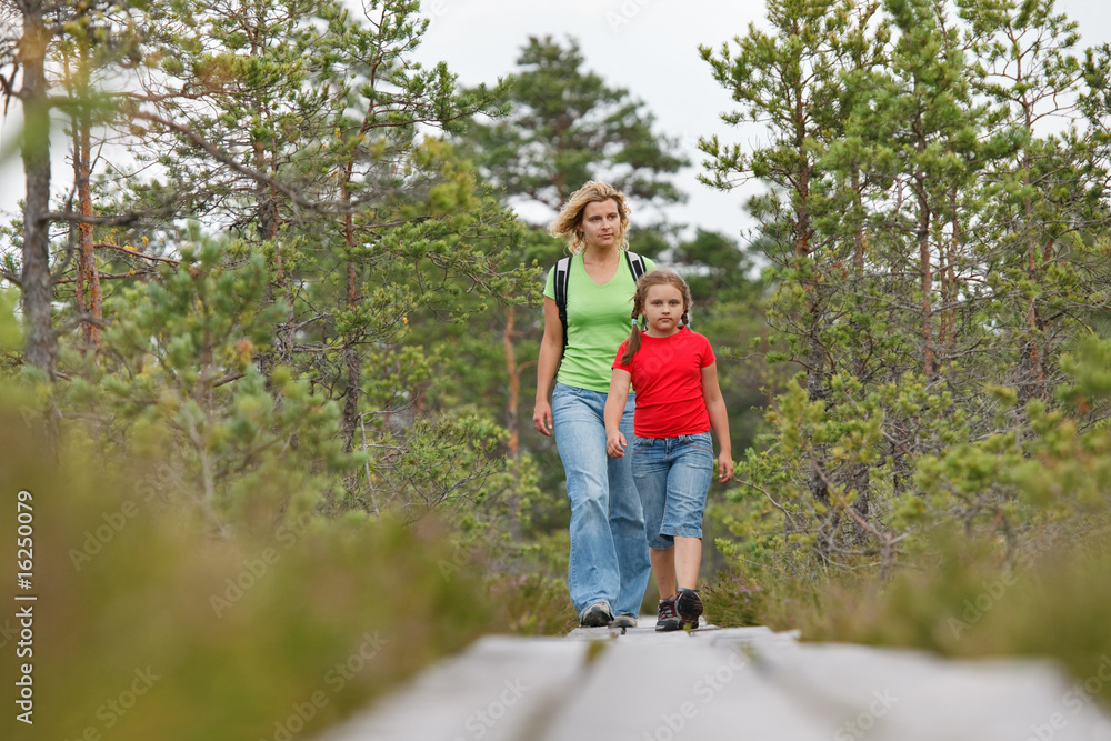 Mother and daughter walking in forest Mother and daughter walking in forest