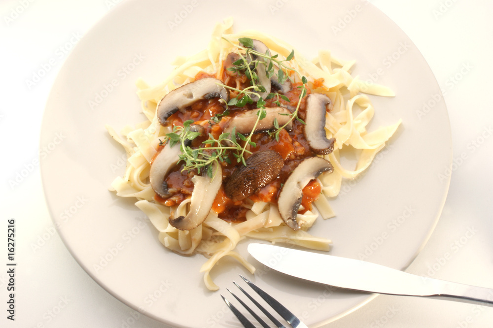 Pasta with mushroom and organic herbs on a pink plate