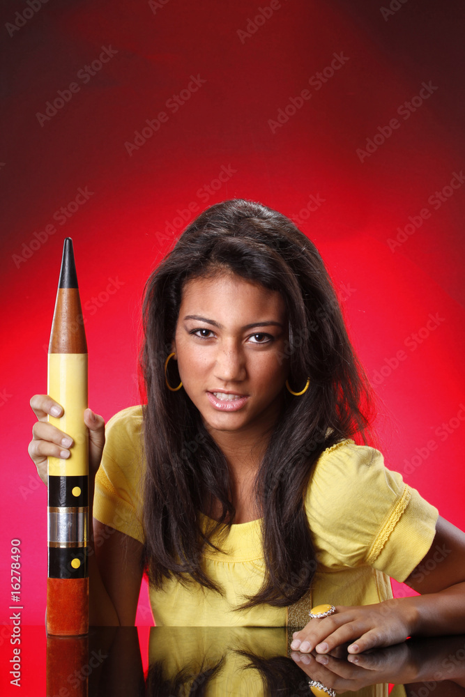 Teenager using an oversized pencil Teenager using an oversized pencil