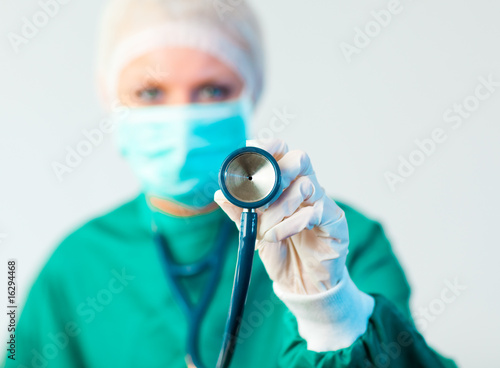 Female Suregon holding stethoscope outwards with focus on the st photo