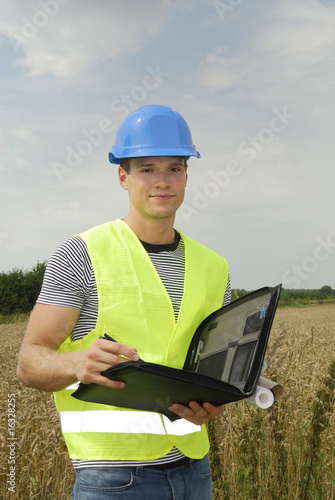 jeune travailleur avec gilet de protection et casque bleu