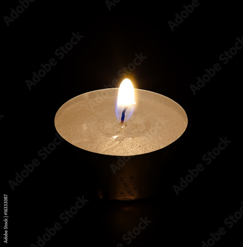 The decorative candle burns on a black background