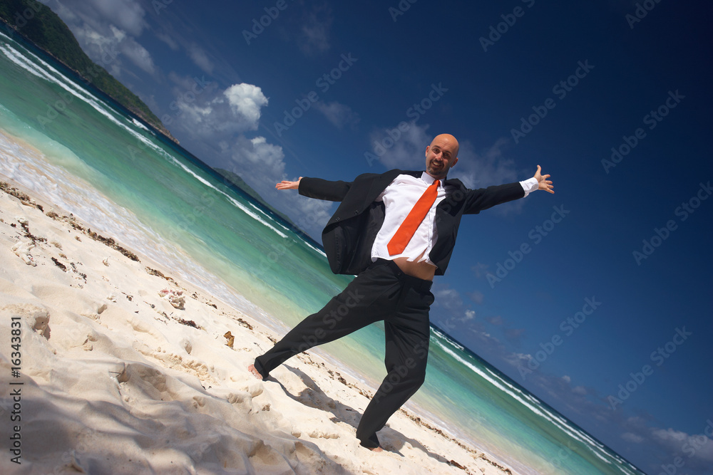 very happy young businessman on the beach