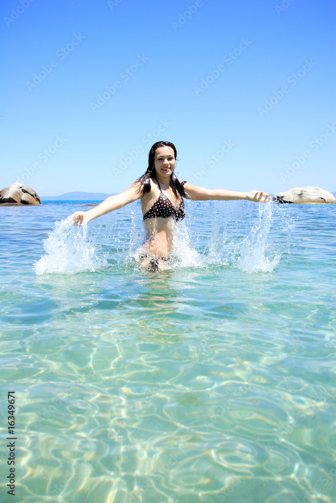 tanned blond woman in bikini in the sea