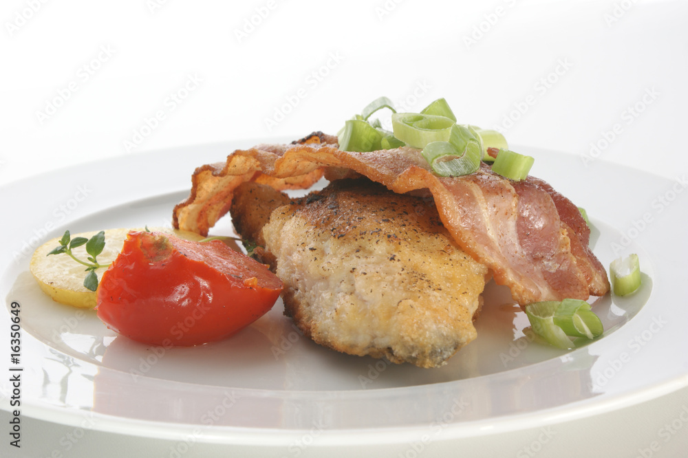 carp with bacon and tomato on a plate