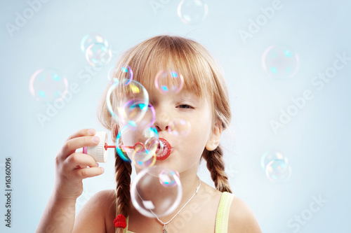 Valokuva Little girl blowing bubbles