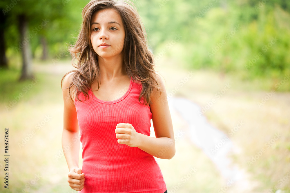 Woman jogging through a forest Woman jogging through a forest