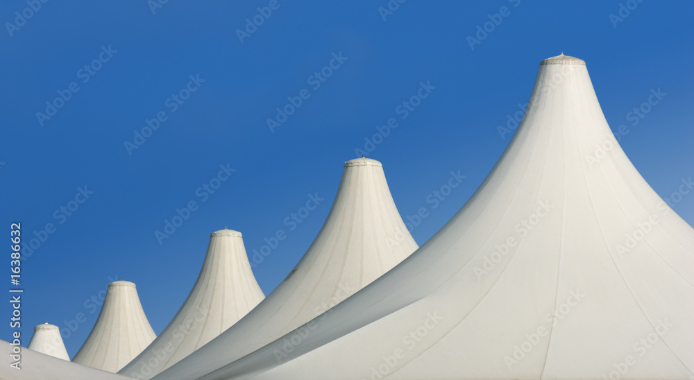 architecture: white roofs of tents aligned over blue sky