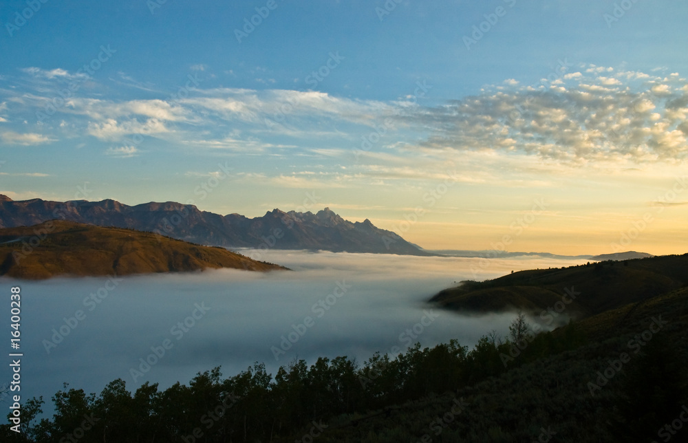 Mountain range and a valley of fog at daybreak