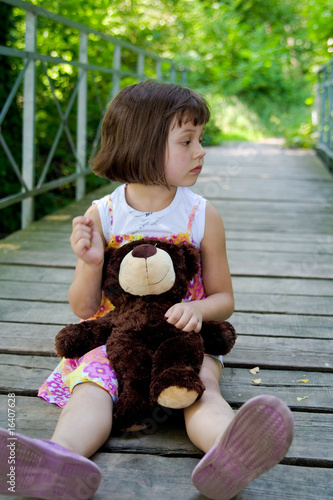 5 years old girl on the bridge with teddy bear