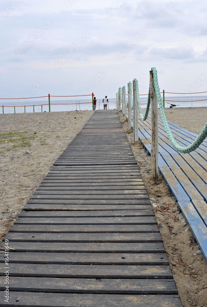 Beach boardwalk to the seaside resort at the sunset