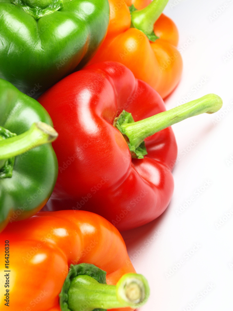 Colored paprikas on white background