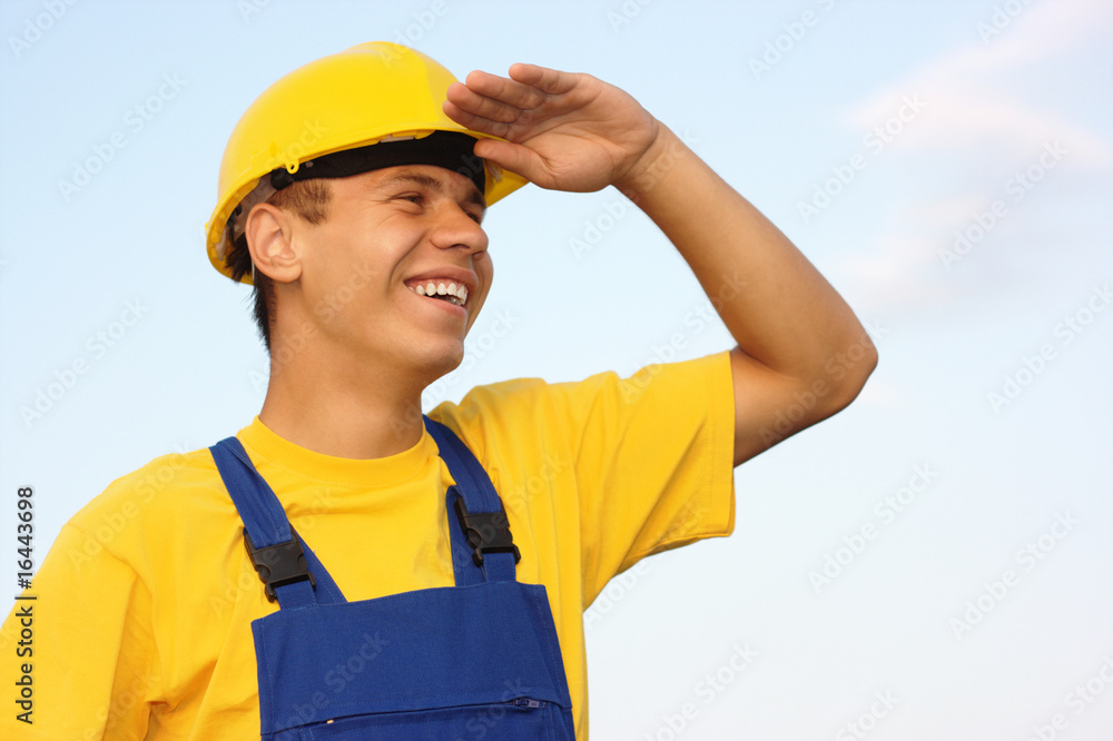 Worker looking forward, covering eyes from the sun Worker looking forward, covering eyes from the sun